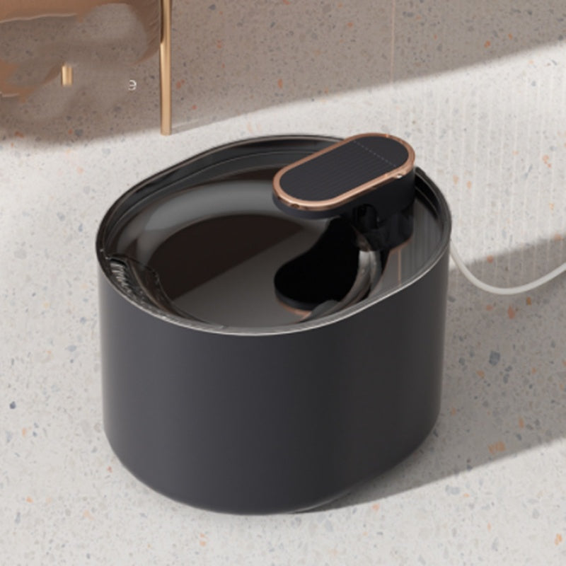 A black automatic pet water fountain with a gold-trimmed top.