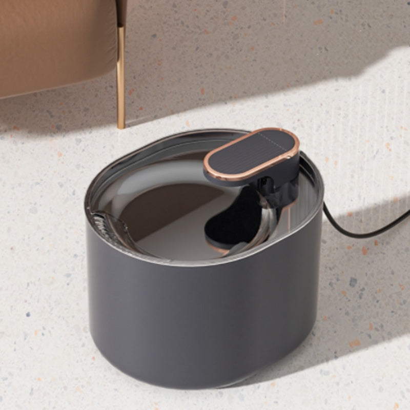 Automatic pet water fountain in dark gray with a clear top and copper accents.